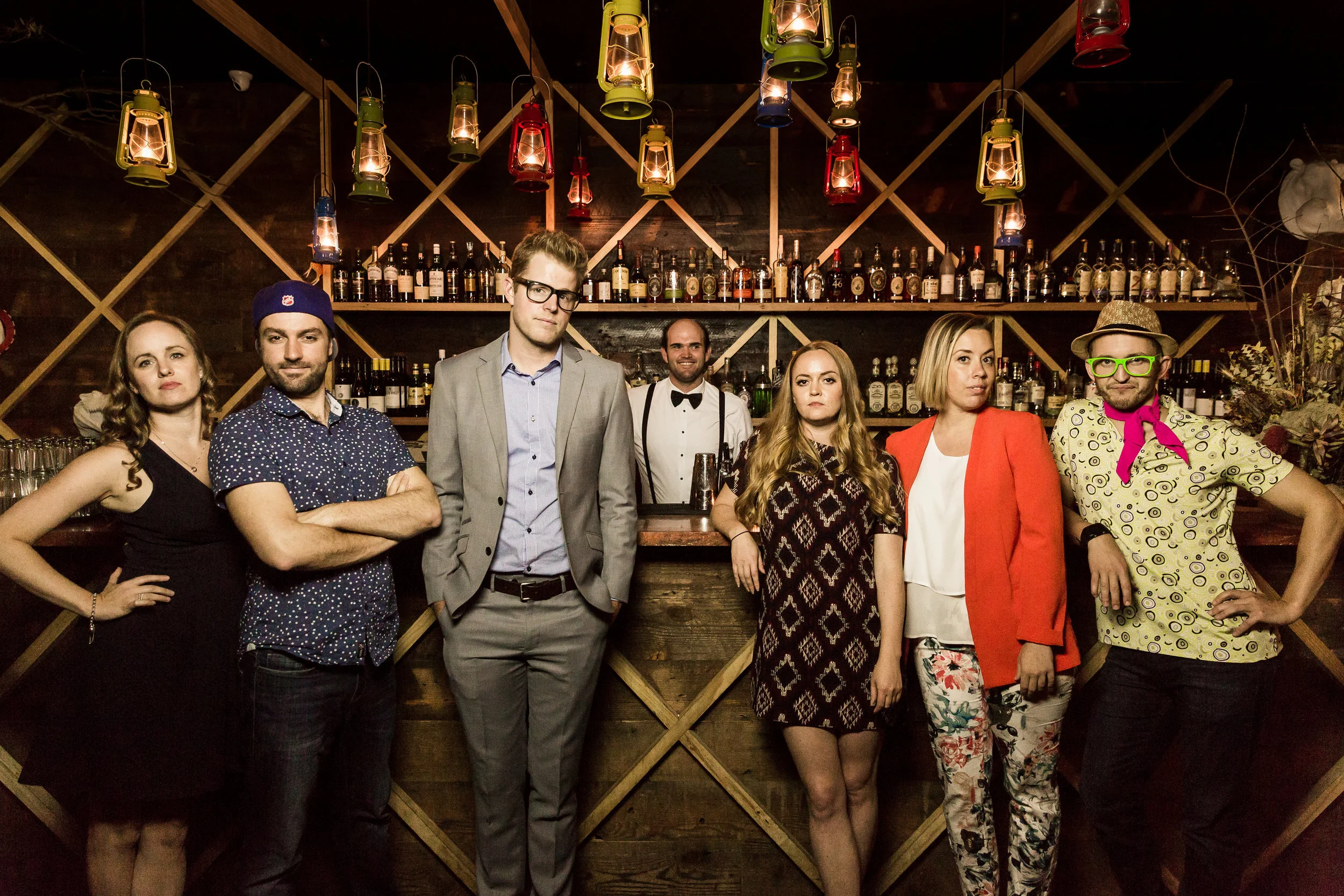 First Date cast portrait in front of a bar with hanging lamps.