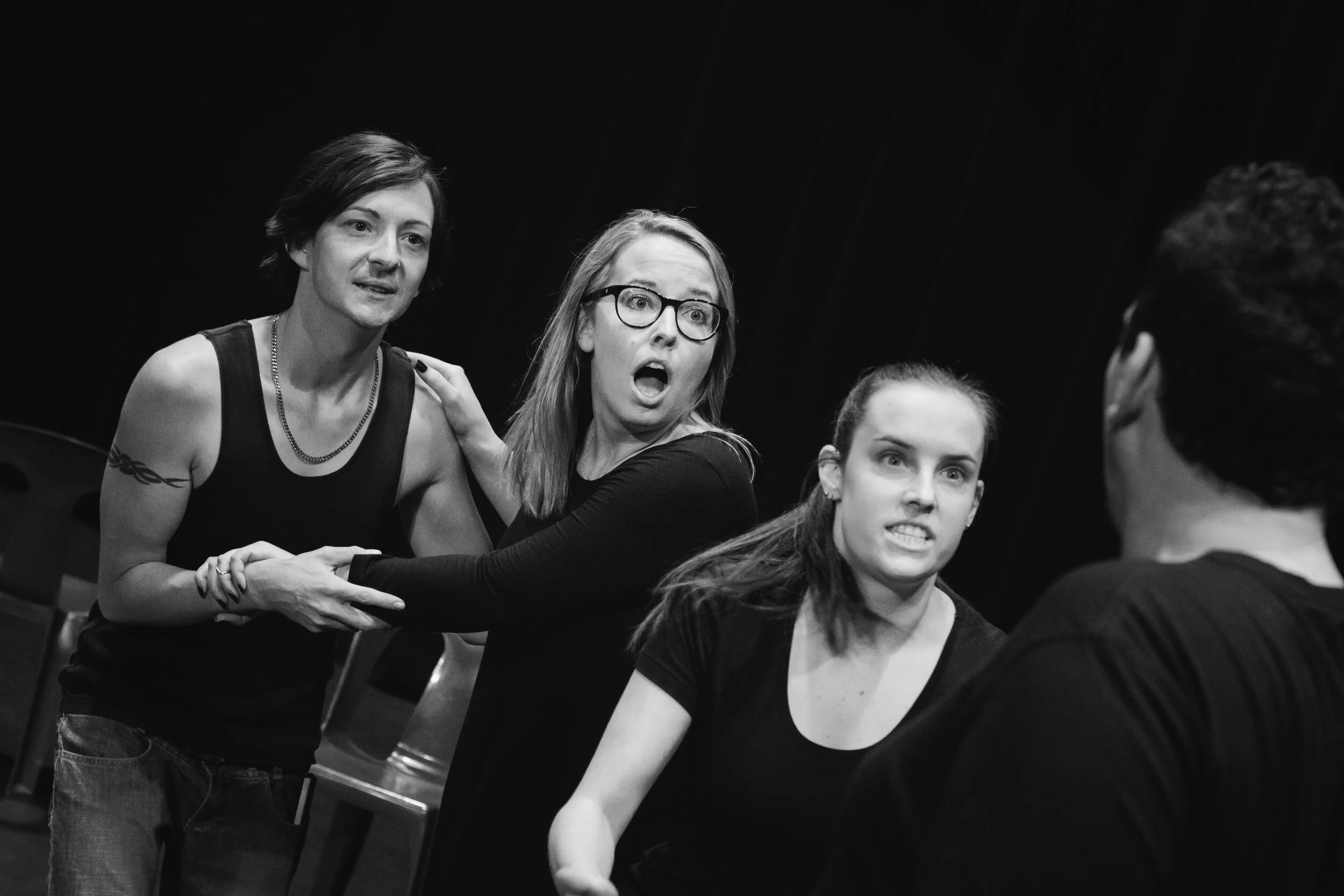 Black-and-white photograph of four [title of show] performers gathered closely together.